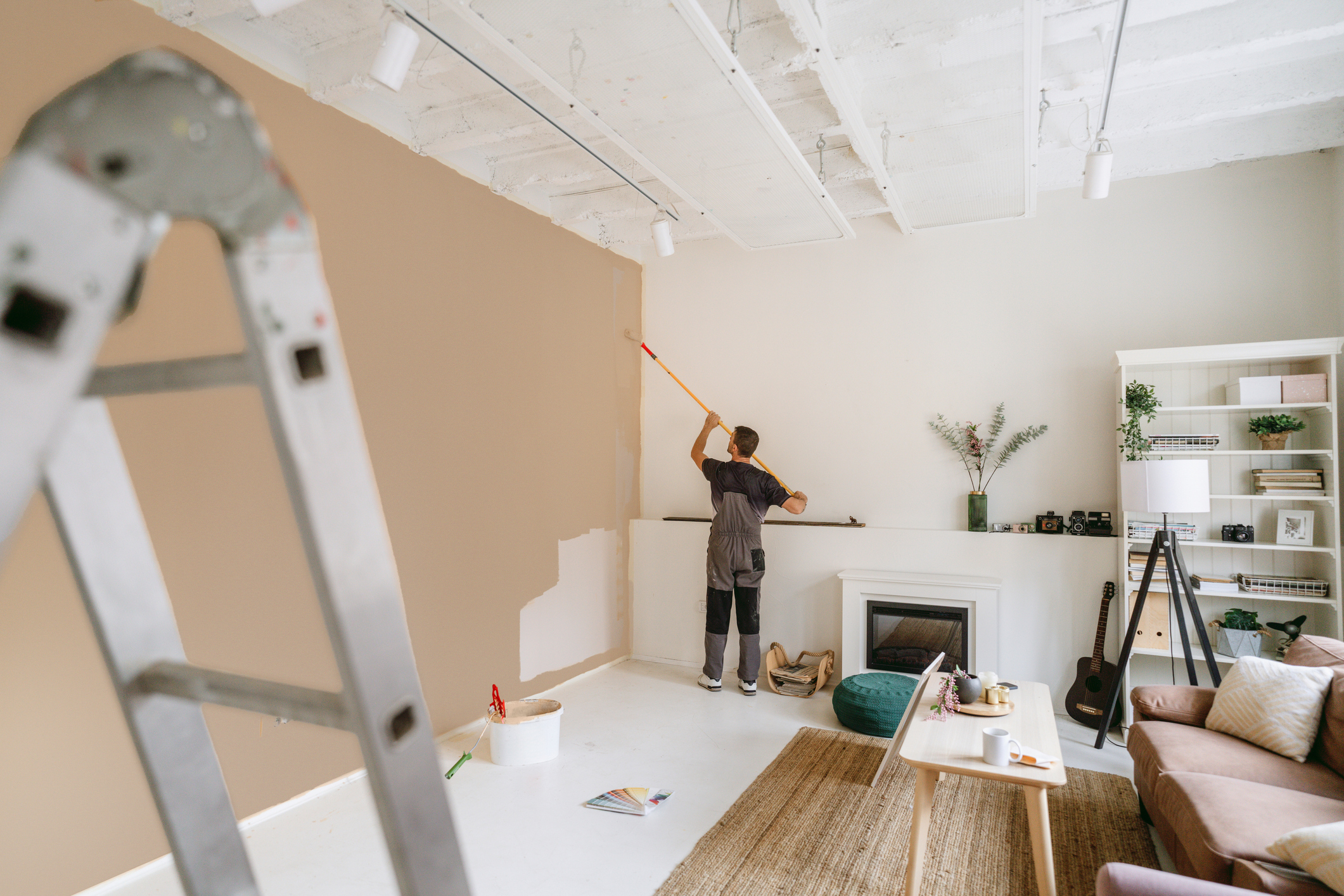 Photo of a professional house painter painting walls in the apartment